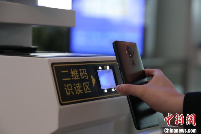 图为旅客使用客票二维码检票乘车。 翟灏 摄 图为旅客使用客票二维码检票乘车。 翟灏 摄